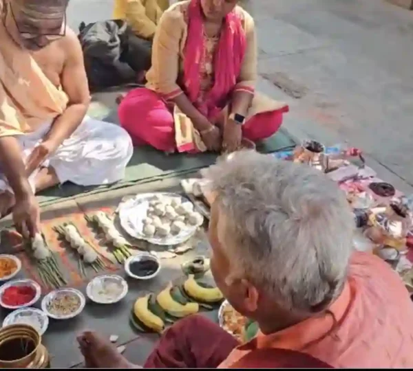 Priest performing rituals for Asthi Visarjan pooja at riverbank.