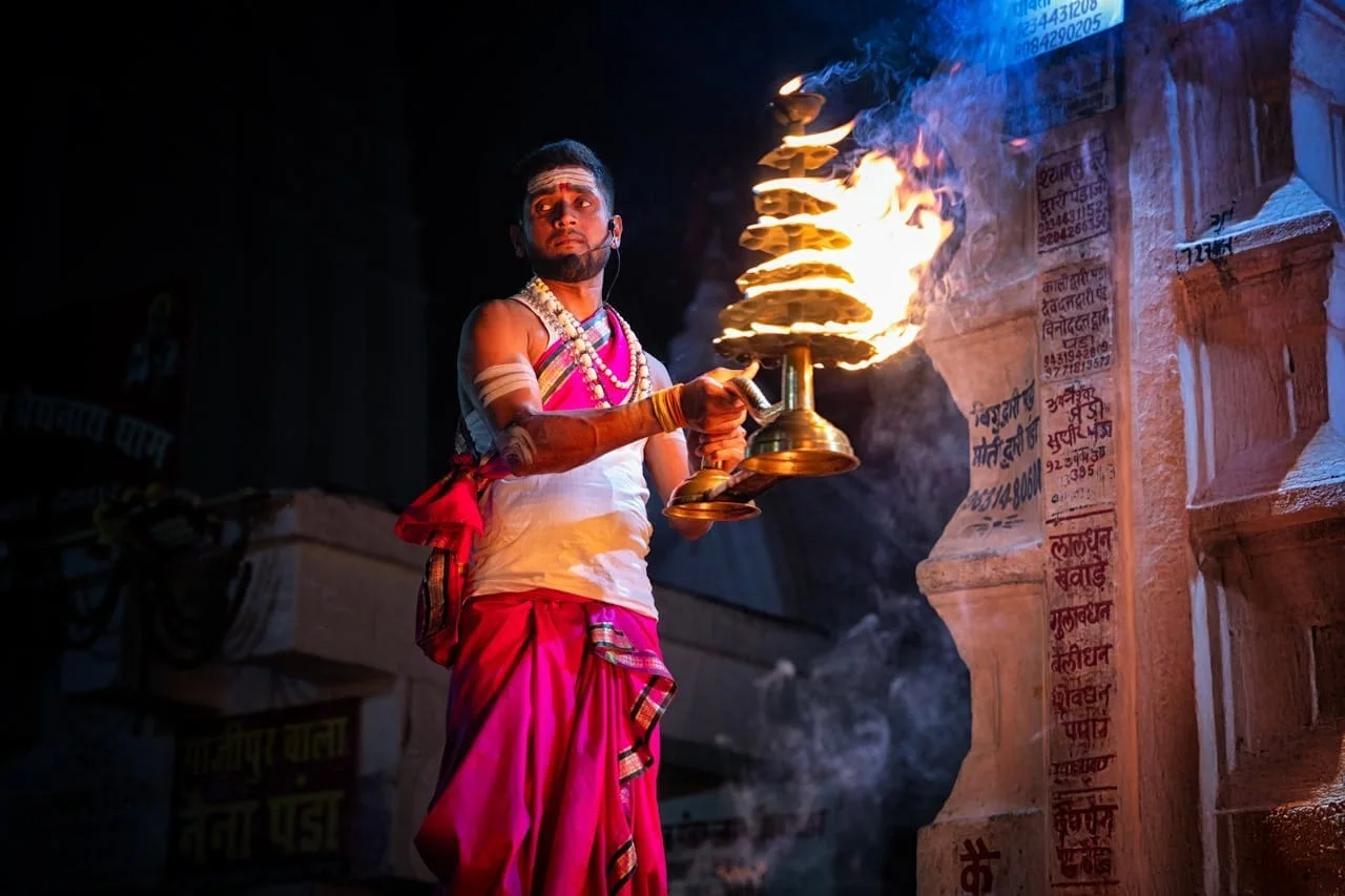 Priest performing Ganga Aarti with fire lamp in Varanasi Kashi India.