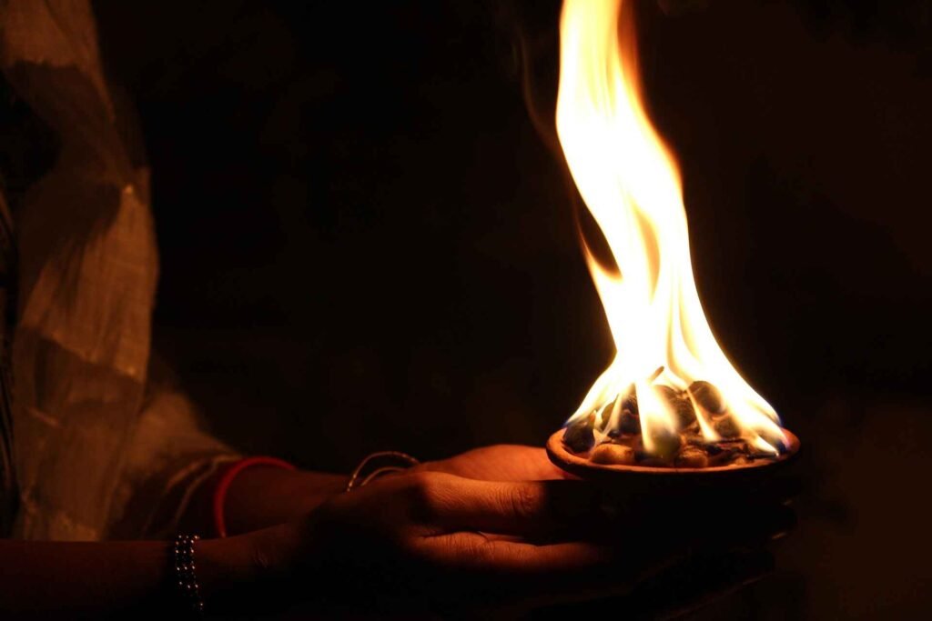 Devotee holding diya during Dev Diwali 2025 celebration before boat booking in Varanasi