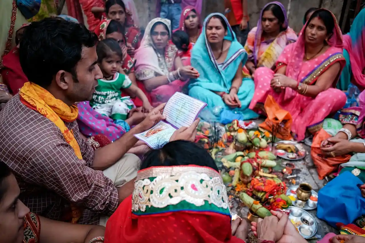 Family sitting with priest and performing traditional Hindu ceremony.