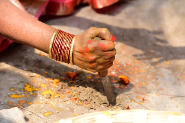 Hindu woman performing final ritual during Pind Daan ceremony in Varanasi with sacred soil and offerings