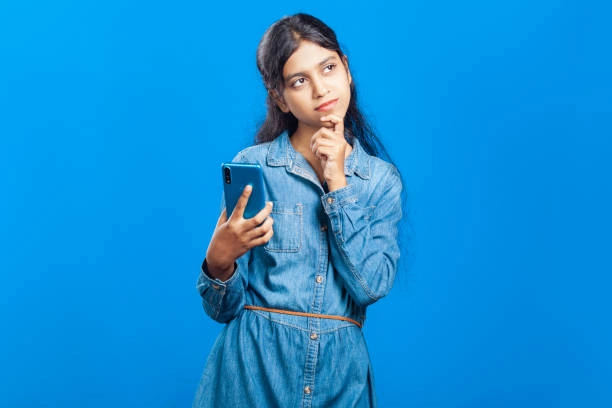 Young woman looking confused while searching for answers about Pind Daan rituals on her phone