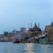 Motor Boat Booking in Varanasi with boats on the Ganga river and iconic ghats in the background during evening ride.