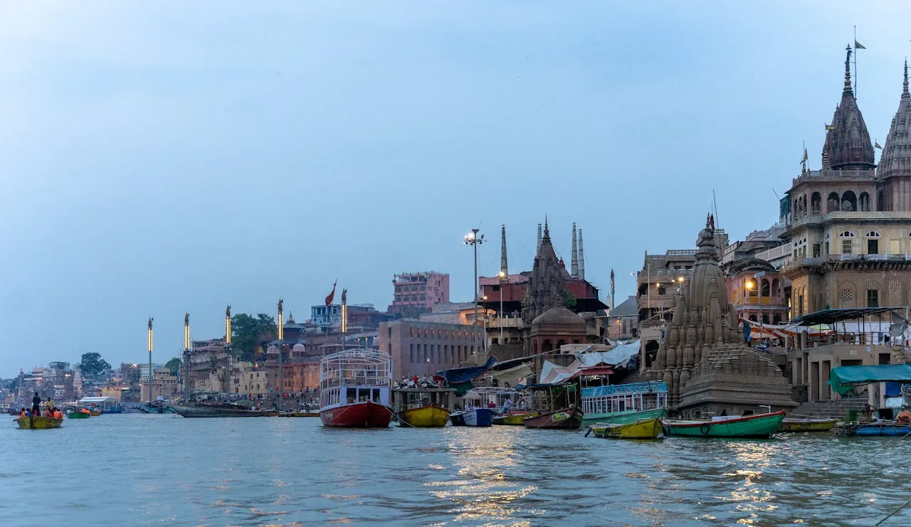 Motor Boat Booking in Varanasi with boats on the Ganga river and iconic ghats in the background during evening ride.